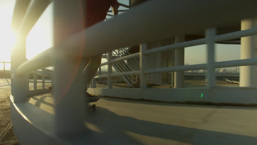 People skateboarding on a ramp with handrails with the sky and clouds in the background