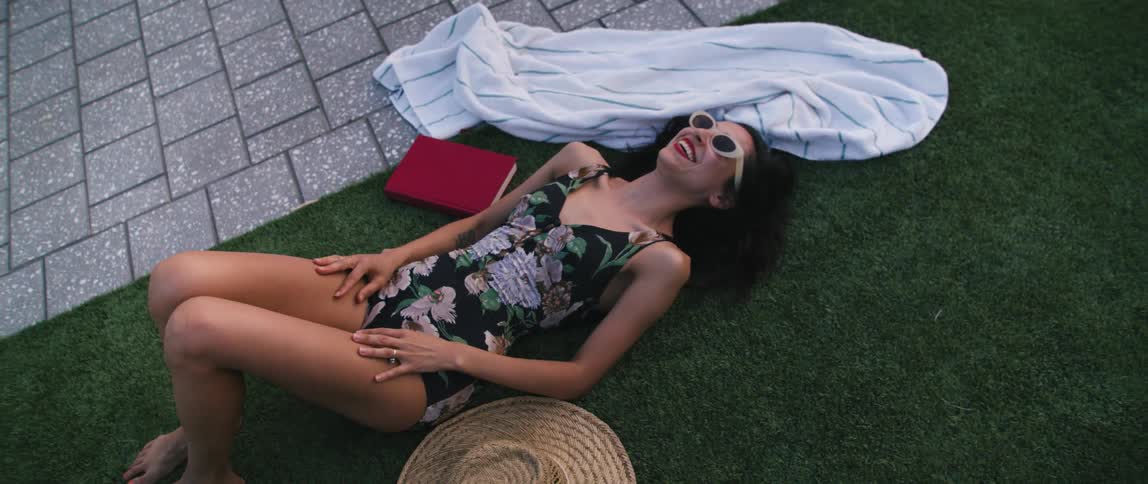 A woman laying and smiling in a swimsuit