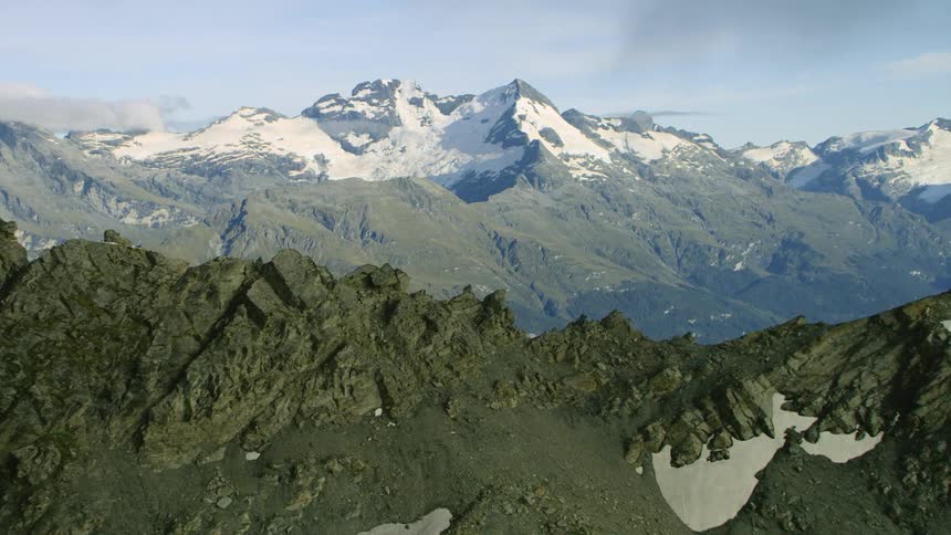 Mountain ridge with snow covered mountains in the distance