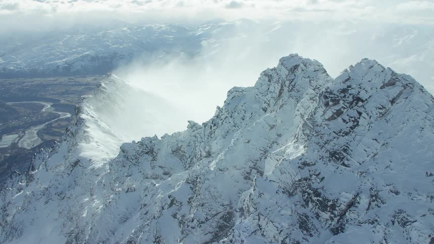 An enormous and jagged mountain range is covered in snow