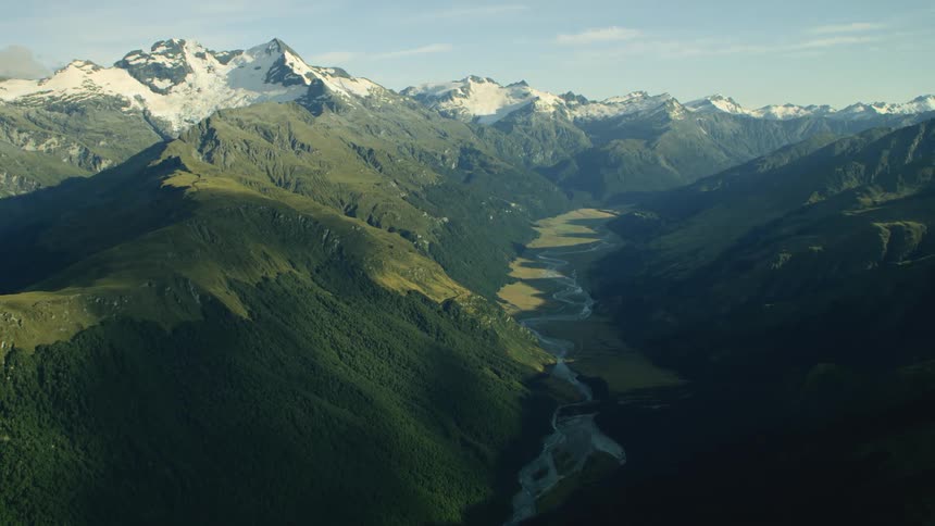 Mountain valley and snow covered mountains in the distance