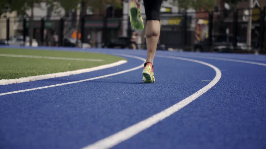 A person skips on a blue track