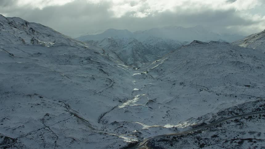 Snow covered mountain ridge under a cloudy sky