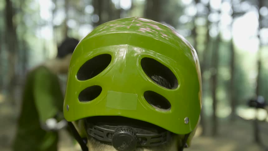 Biker wears green helmet in the forest