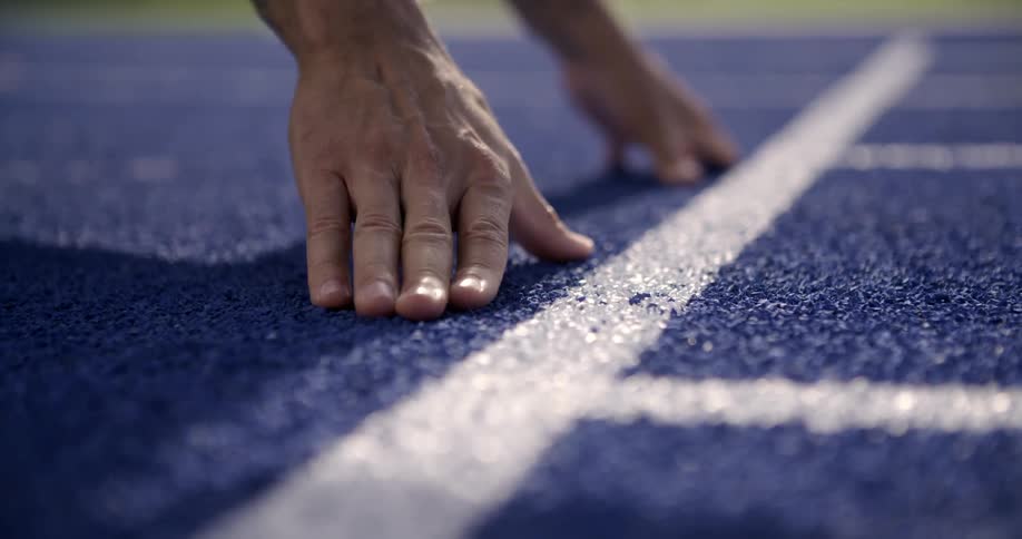Two hands place to start a race on a track