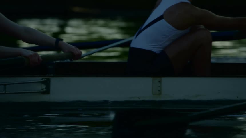 A group of women are rowing a boat on a lake