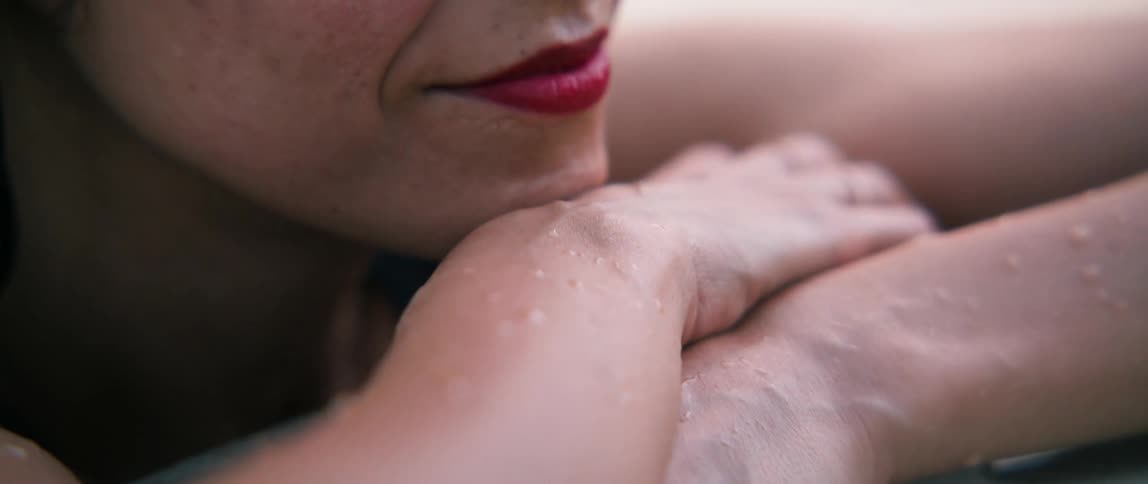 A woman in a pool leaning on the edge