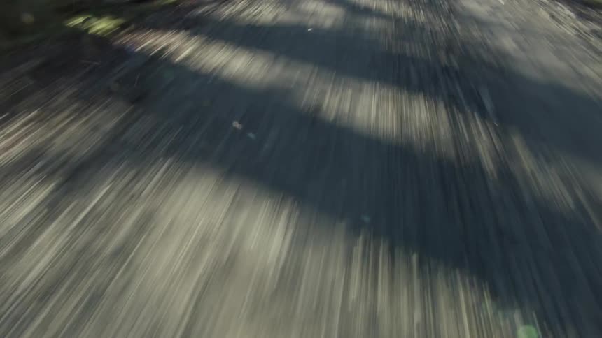 A vehicle travels down a gravel road in the countryside during the day