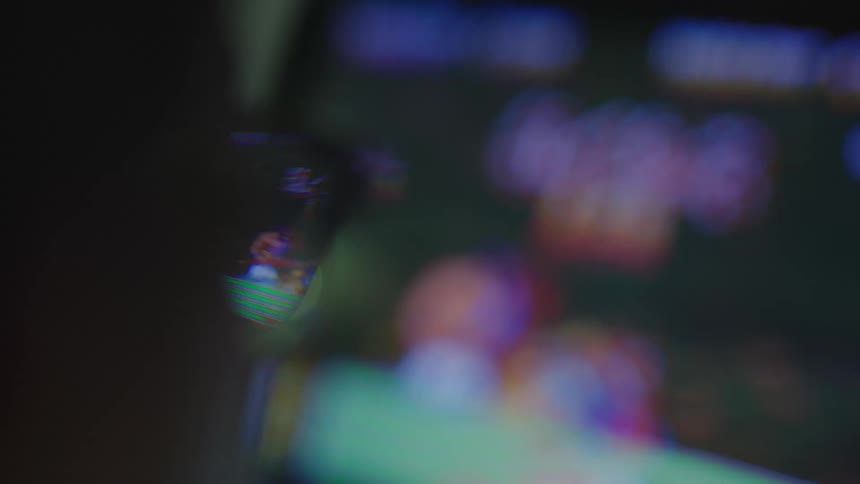 A person with glasses playing in arcade