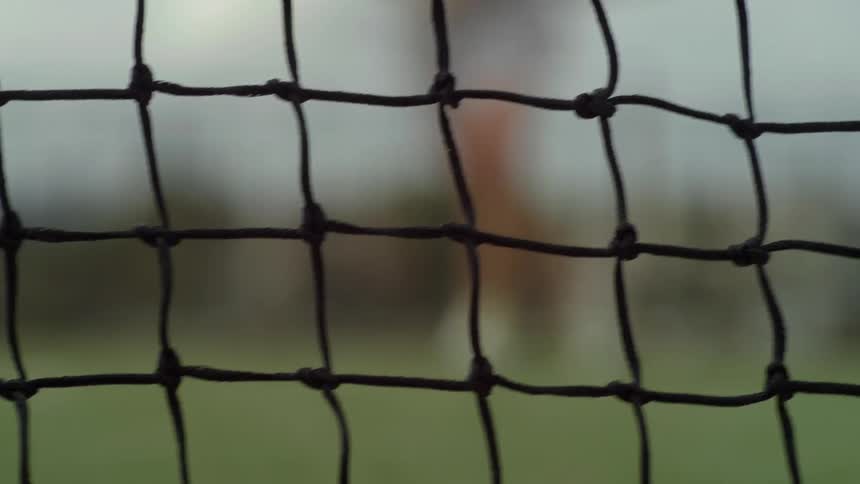 Two people playing a game run back and forth in front of a net