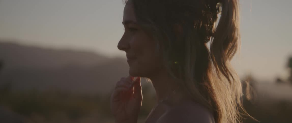 A woman turning and smiling at dusk
