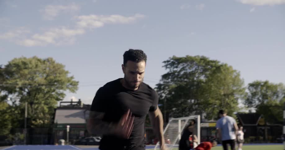 A man sprints on an athletic track during the day