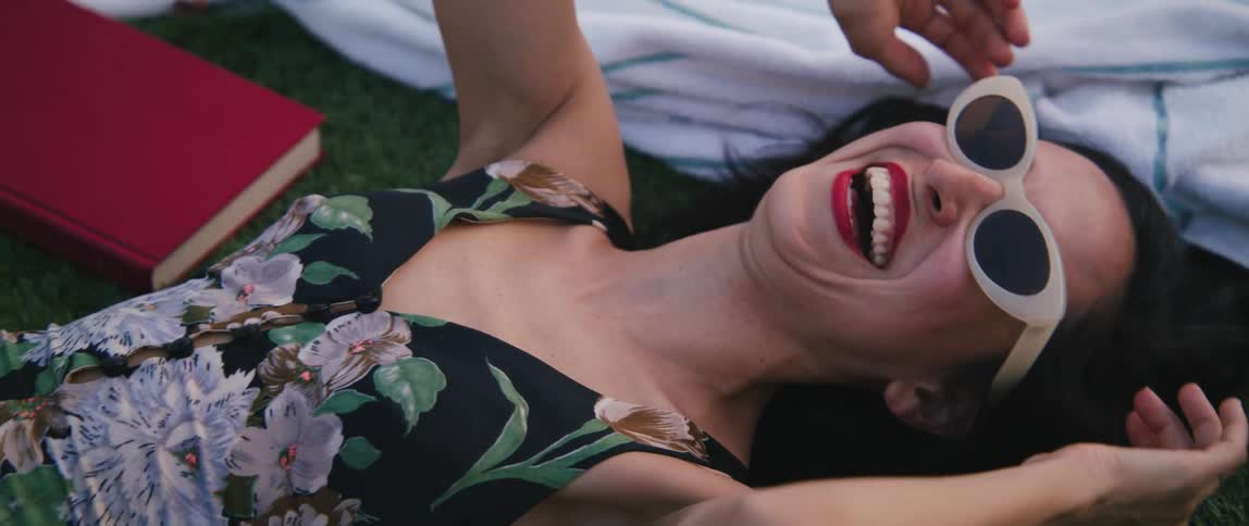A woman laying on the grass and laughing
