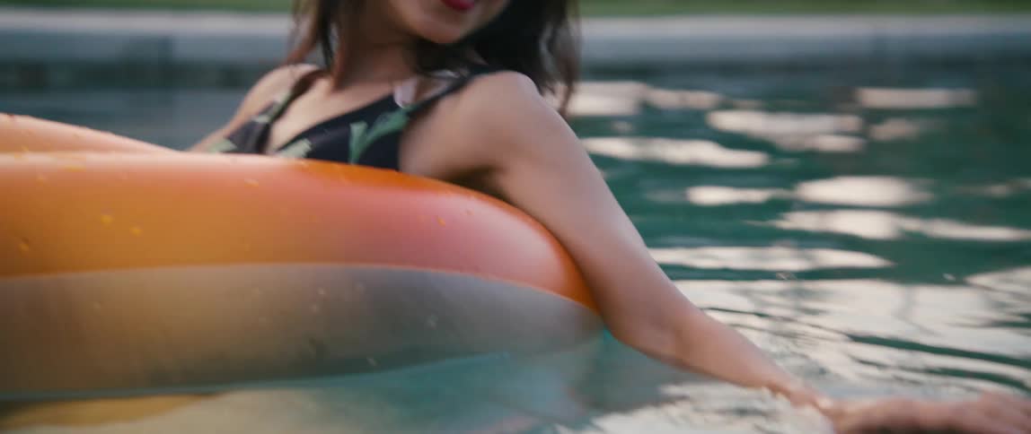 A woman smiling and relaxing in a pool