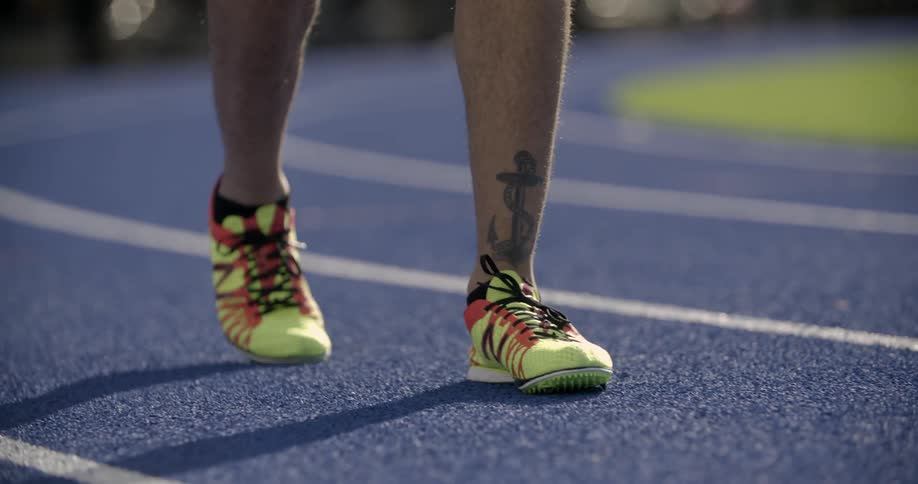A person is walking along a running track