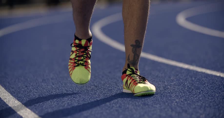 A person walks on a blue track