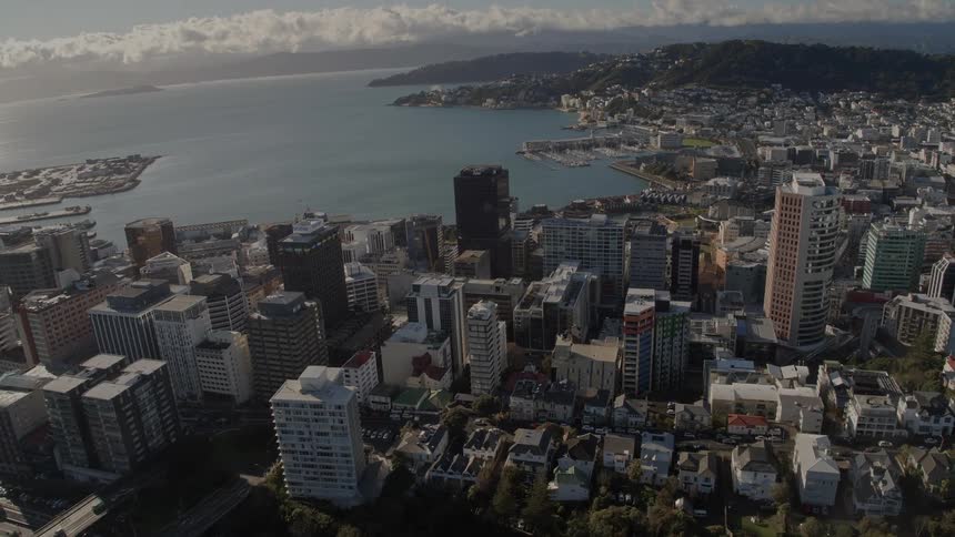 Aerial view of a waterfront city next to the ocean at evening