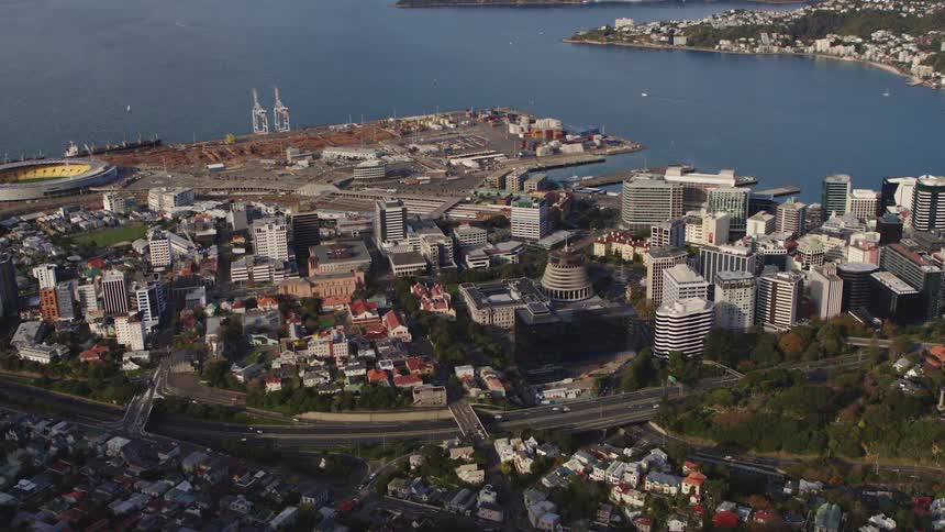 City next to the lake with cars traveling on the city streets