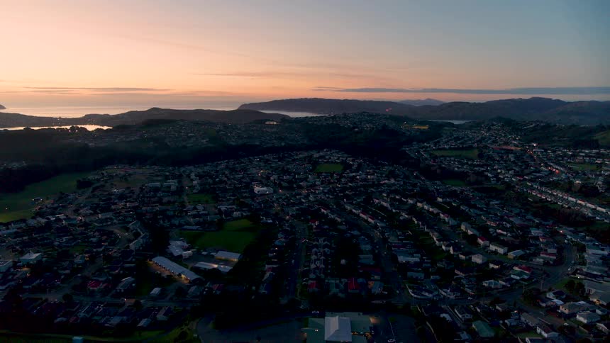 Aerial view of the suburbs of a town near the ocean at sunset