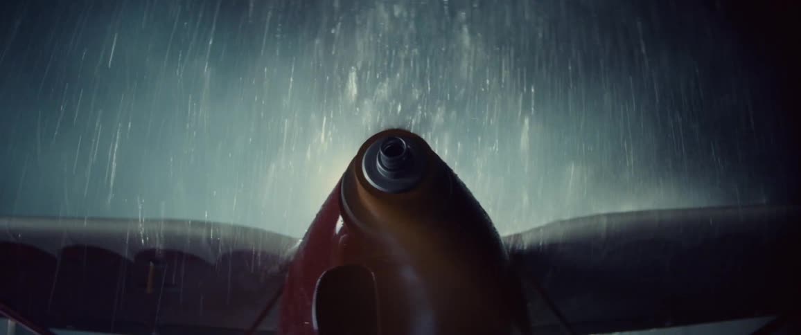 Airplane propeller starts rotating as heavy downpour falls onto wings
