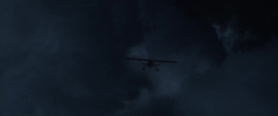 Airplane with the landing gears down flies into storm cloud as lightning strikes across the sky