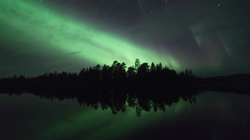 Time-lapse of amazing green northern lights and still water