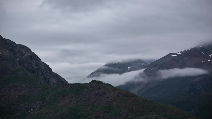 Time lapse of fog forming between mountains