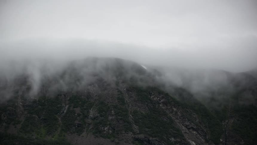 Fog rolling over the top of a mountain
