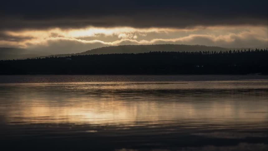 Clouds float over a rippling body of water