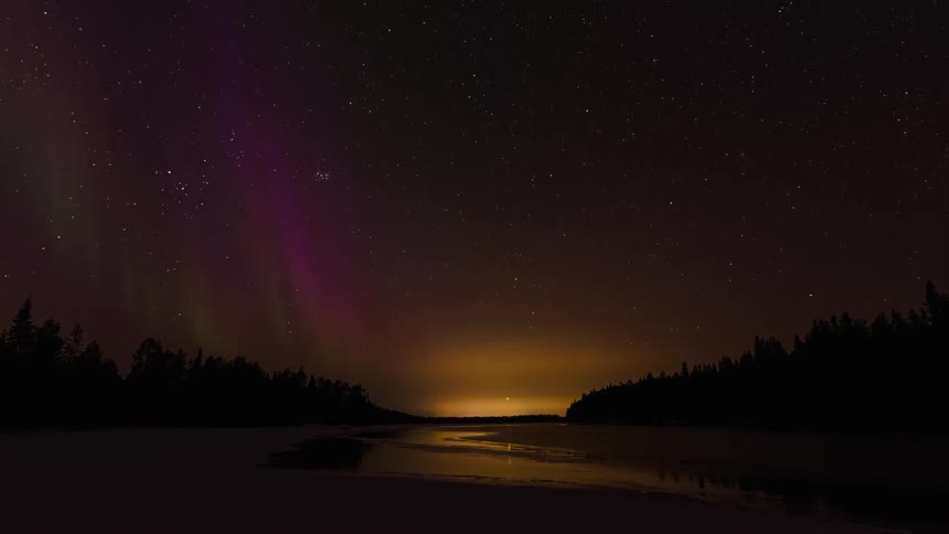Purple northern lights over a snowy river