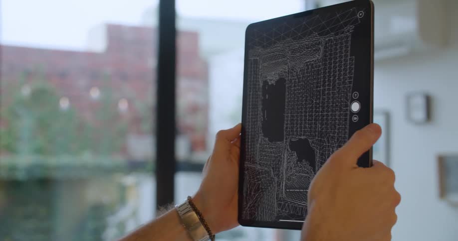 Man holding a tablet on his hands scans the walls of an apartment