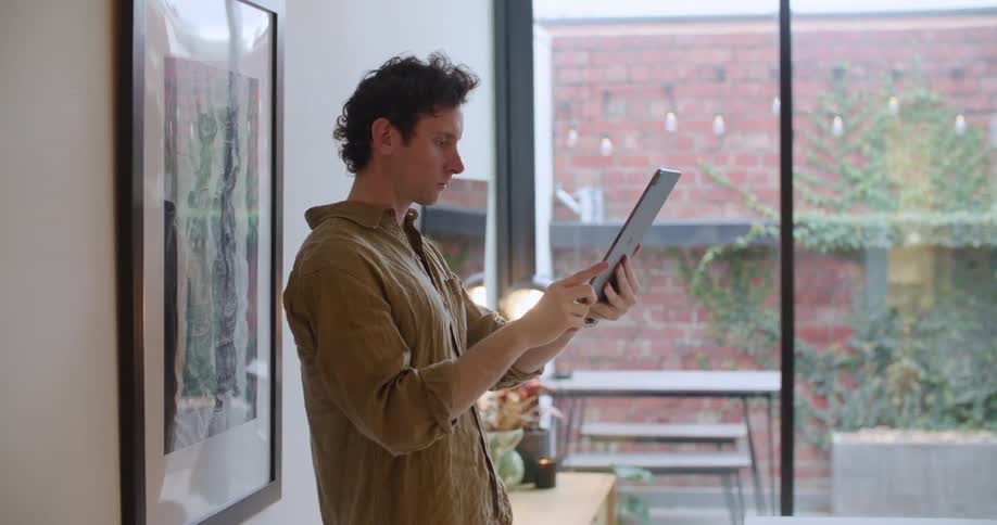 A man trying to take a photo with a tablet