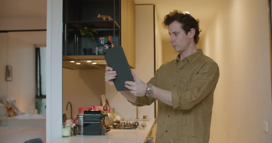 Man moves tablet around filming apartment
