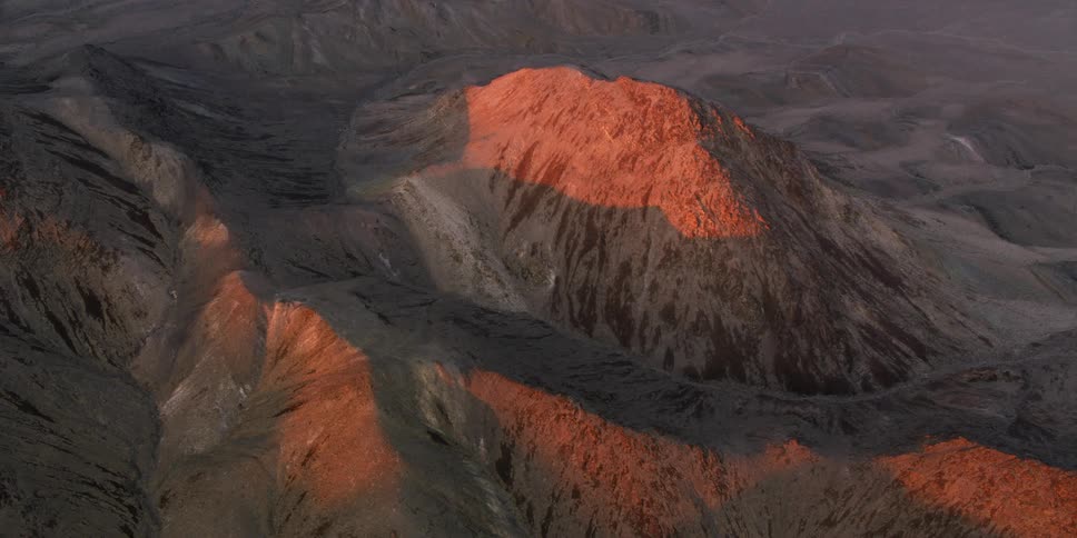 Lava glows bright orange under the surface of a volcano