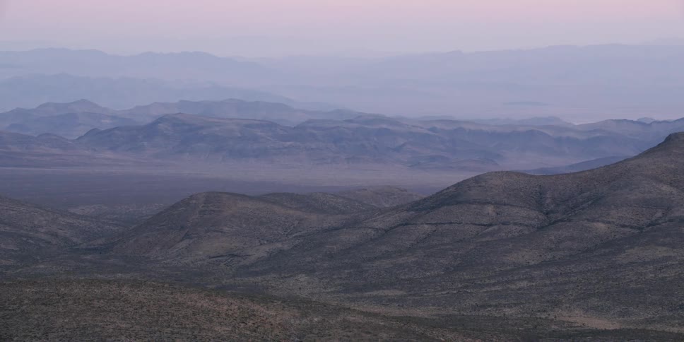 A view of hills and a landscape at dusk