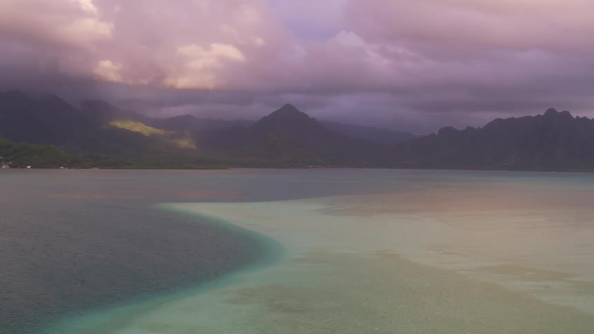 A mountainous coastline shrouded in fog on a cloudy day