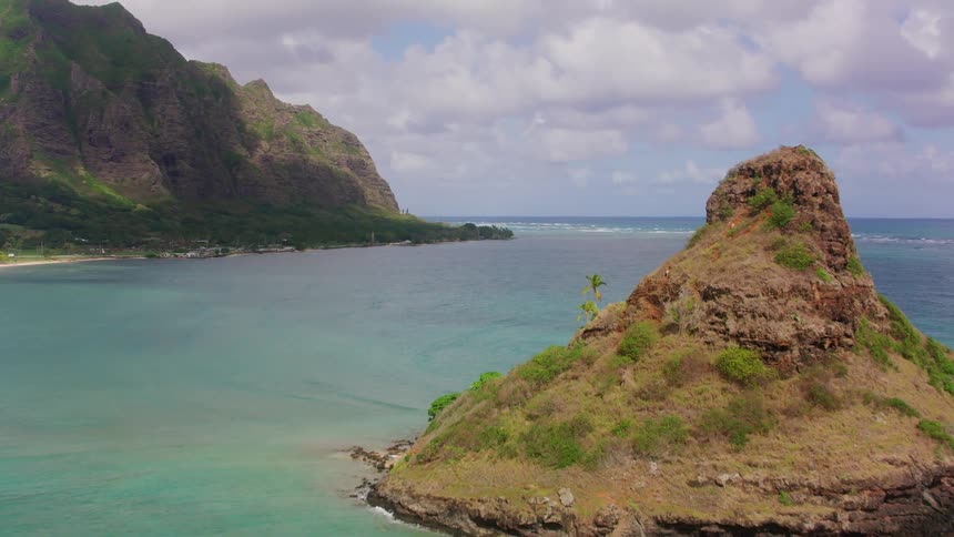 A car drives along a road along a mountainous coastline