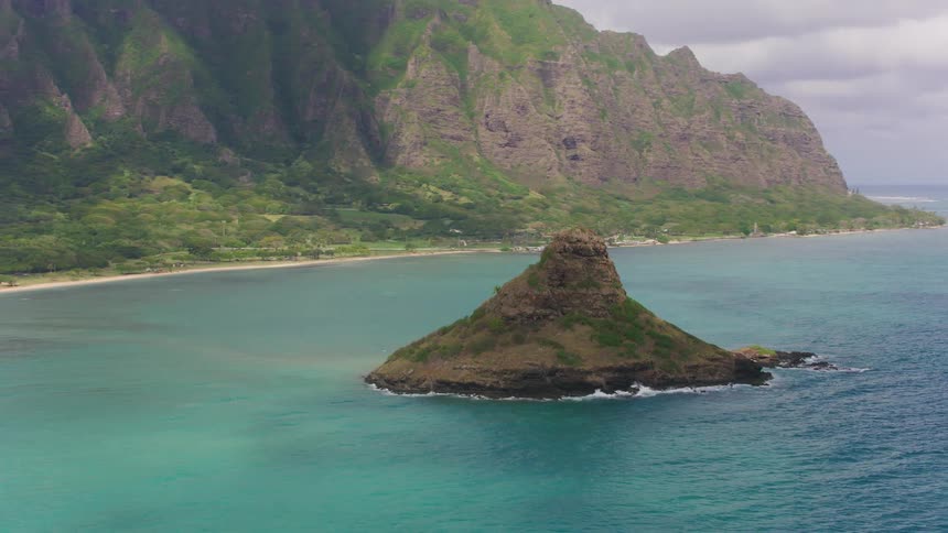 Aerial view of a small island on the coast near a mountain range