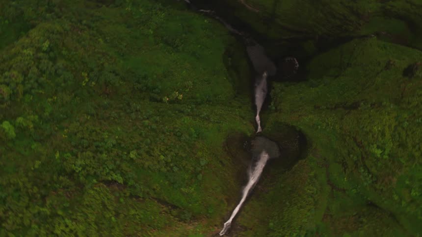 An aerial view of a hill with a waterfall