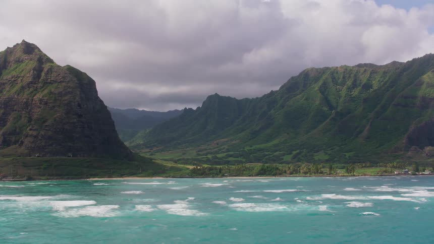 Aerial shot of a mountain valley by an ocean