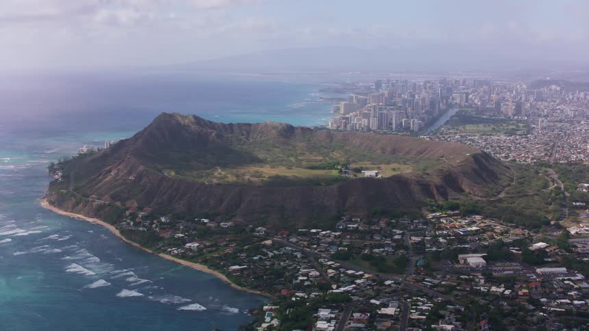 A city on the coast almost surrounds a volcano crater