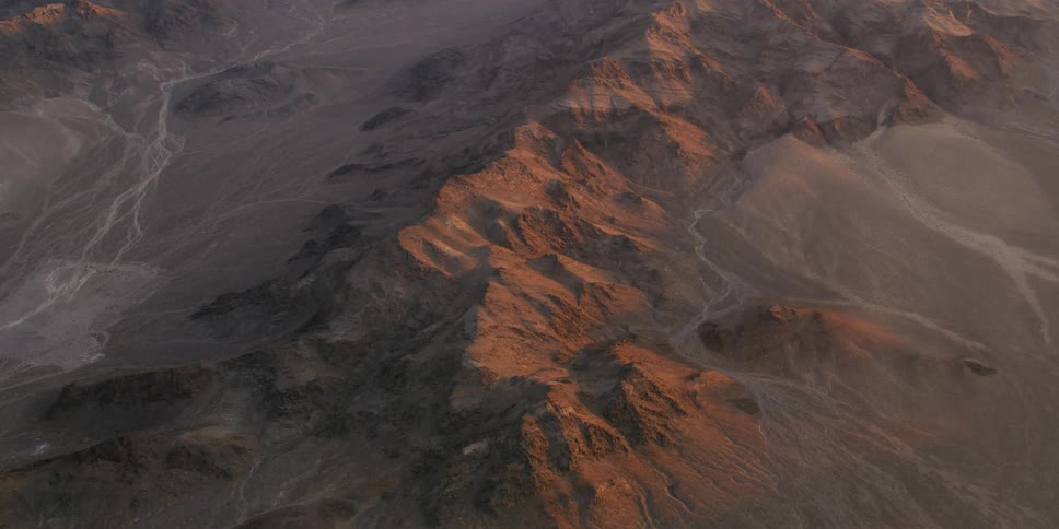 Aerial view of a mountain range in the desert at sunset