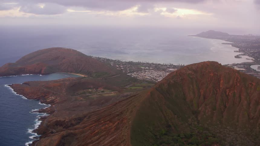 Town occupies ocean shore near reddish mountain