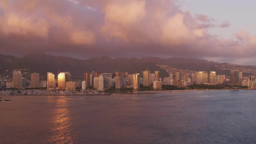Aerial view of the skyline of a coastal city at sunset