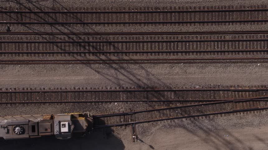 Top down view of a freight train driving on train tracks
