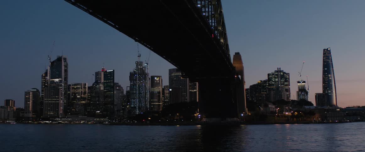 A bridge over water in front of high rise buildings in a downtown area