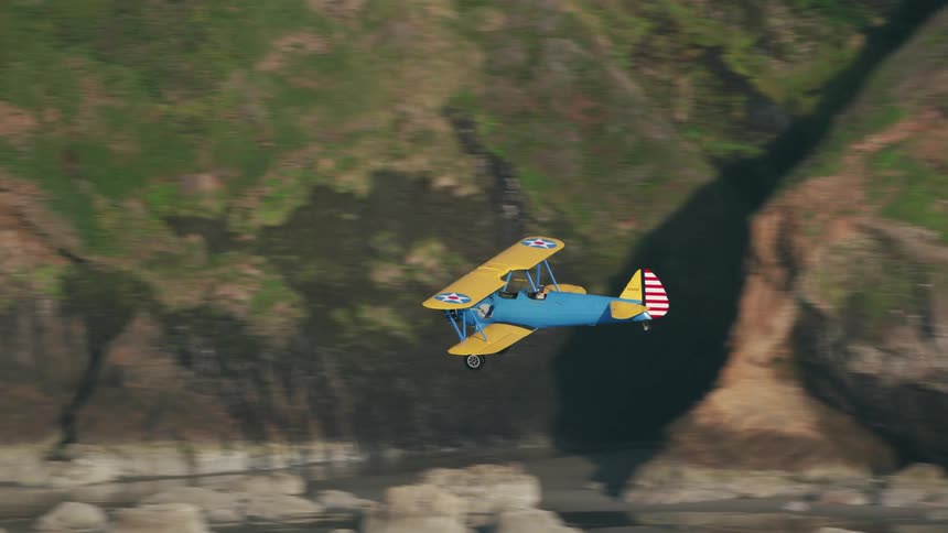 A plane flies past the coast by the mountains