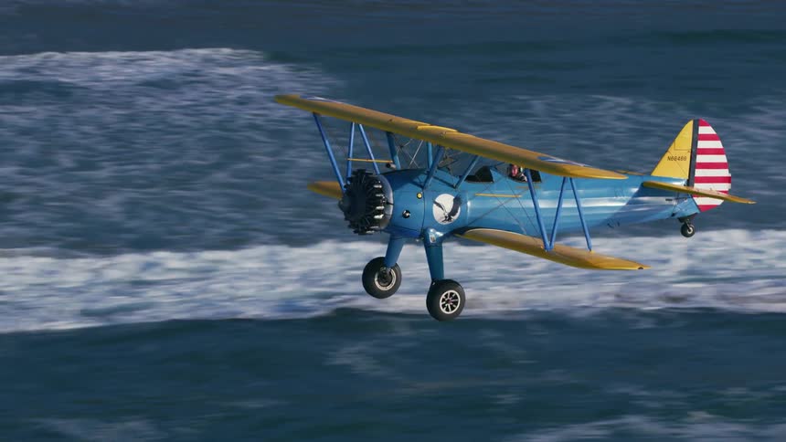 A person is flying a plane over the water