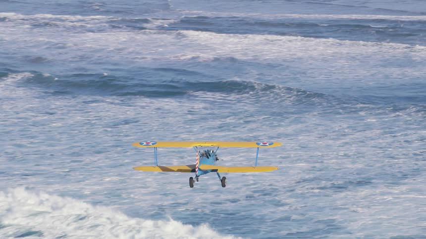 An airplane flying over a beach with water waves and sand