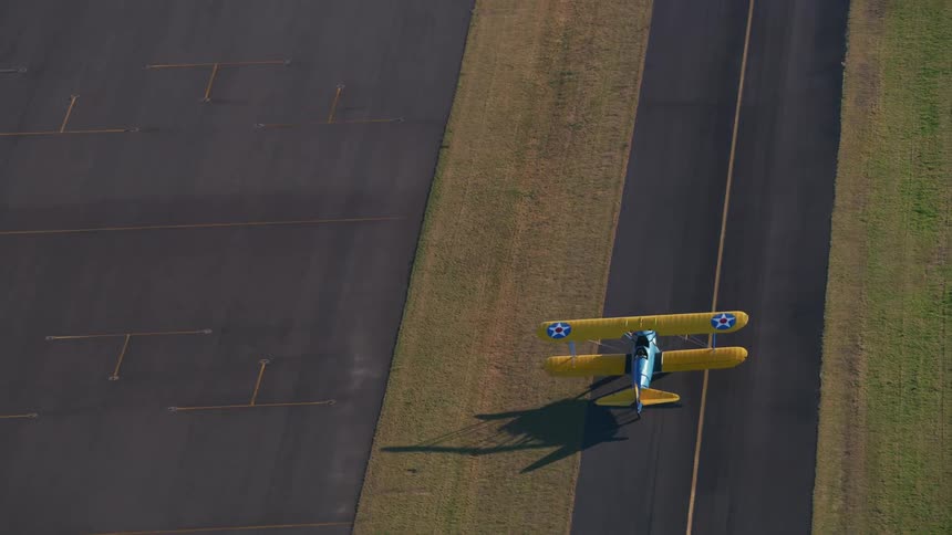 An airplane driving in a runway with asphalt and lines